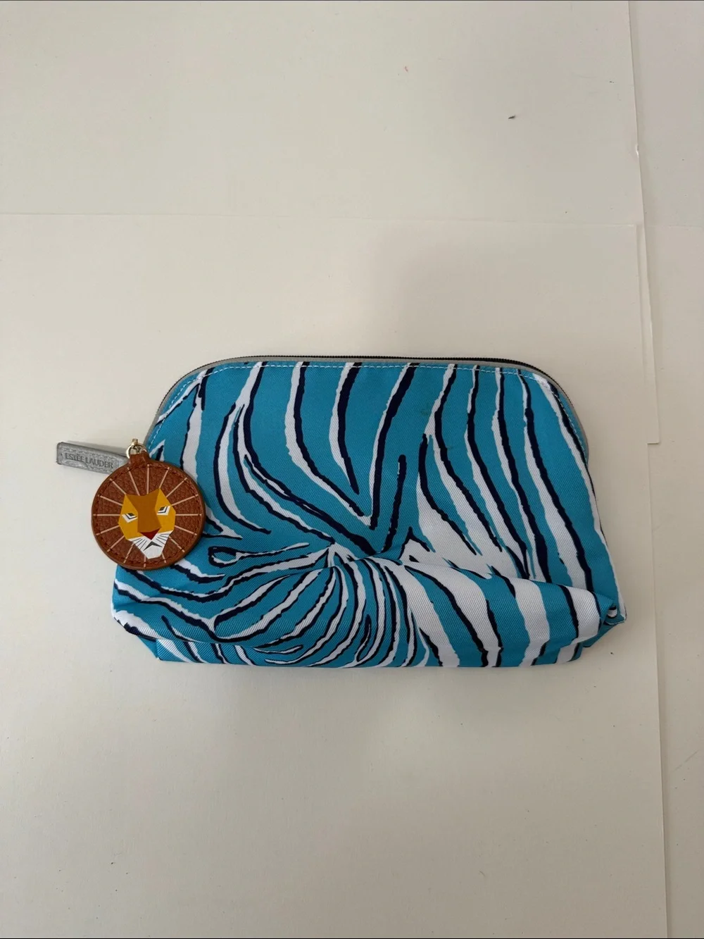 Estee Lauder Turquoise and White Zebra-Print Cosmetic Pouch with Lion Charm